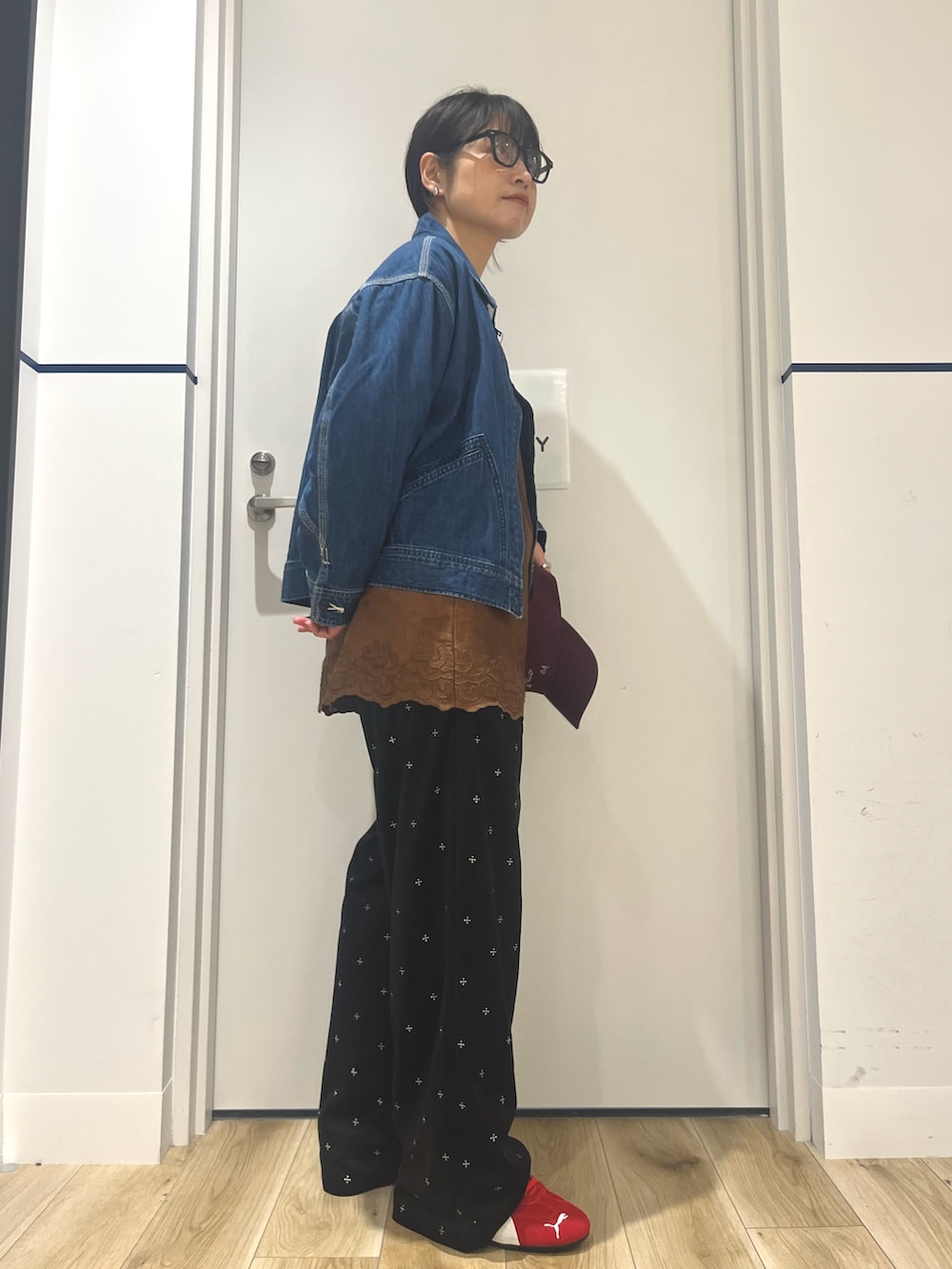 ブラック系のその他パンツ、レッド系のスニーカー、ブルー系のデニムジャケットを着用したレディースの秋コーディネートの2枚目の写真