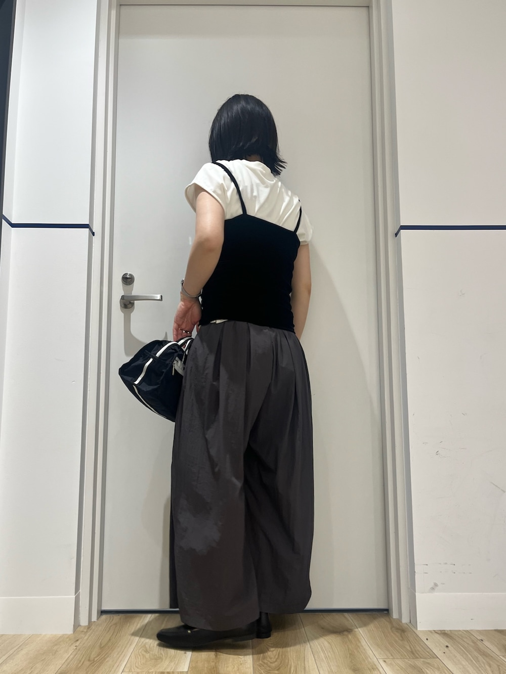 ブラック系のショルダーバッグ、グレー系のその他パンツ、ホワイト系のTシャツ/カットソーを着用したレディースの夏コーディネートの2枚目の写真