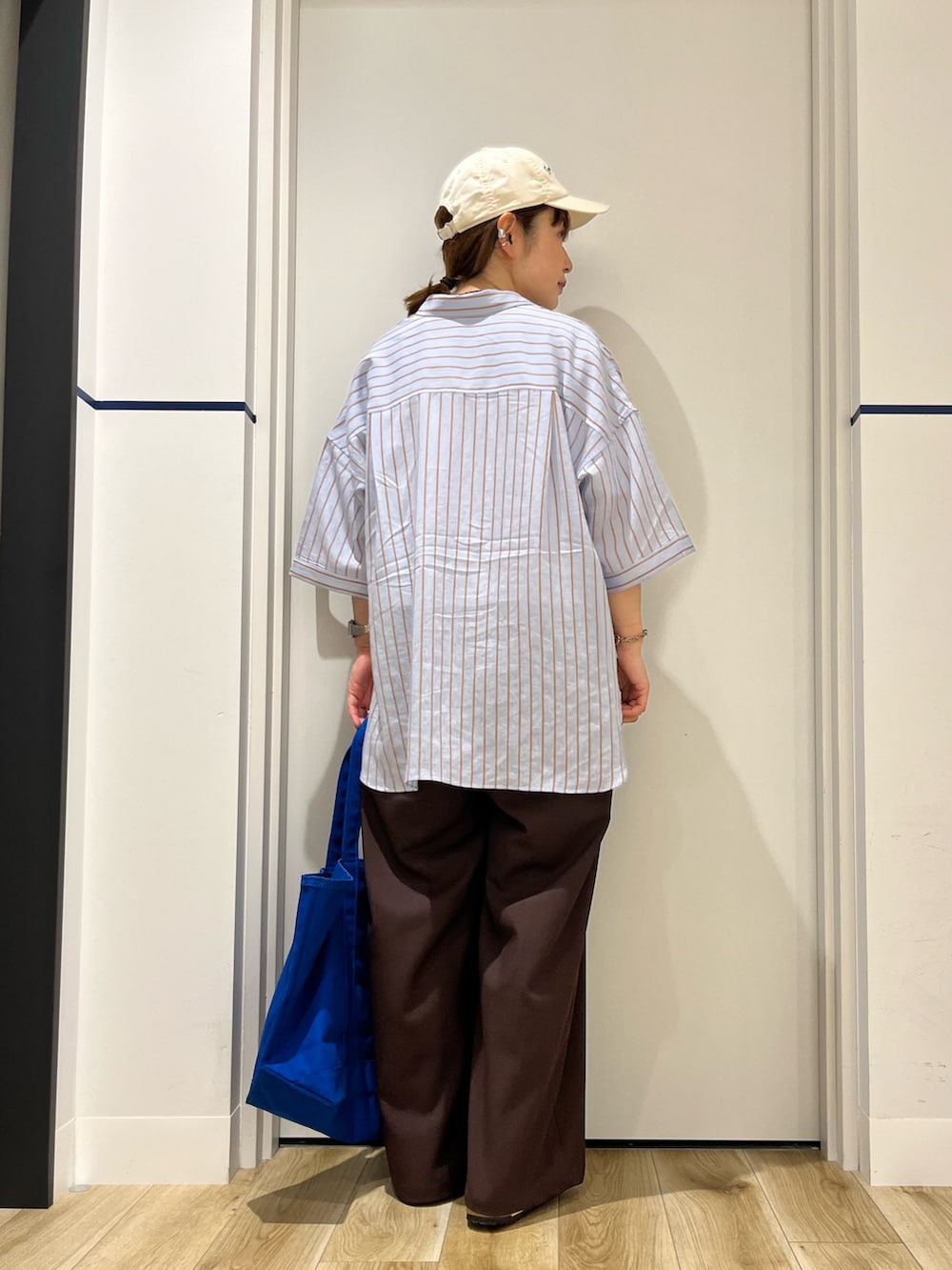 ブラウン系のその他パンツ、ベージュ系のサンダル、ブルー系のトートバッグを着用したレディースの夏コーディネートの3枚目の写真