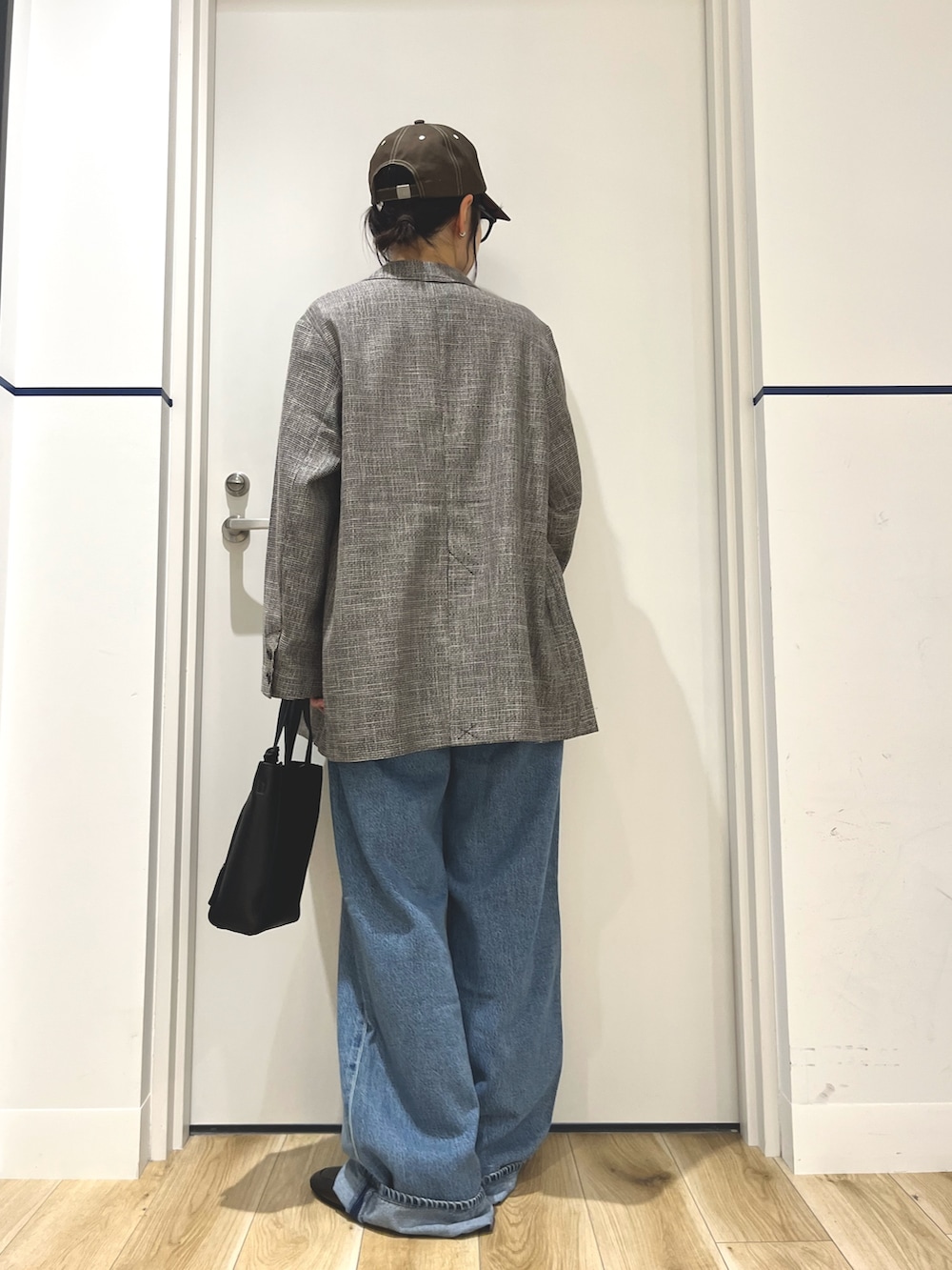 グレー系のその他アウター、ブルー系のデニムパンツ、ブラック系のトートバッグを着用したレディースの秋コーディネートの3枚目の写真