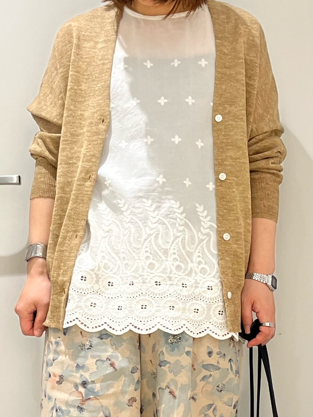ベージュ系のカーディガン/ボレロ、ホワイト系のシャツ/ブラウス、ブラック系のショルダーバッグを着用したレディースの春コーディネートの4枚目の写真