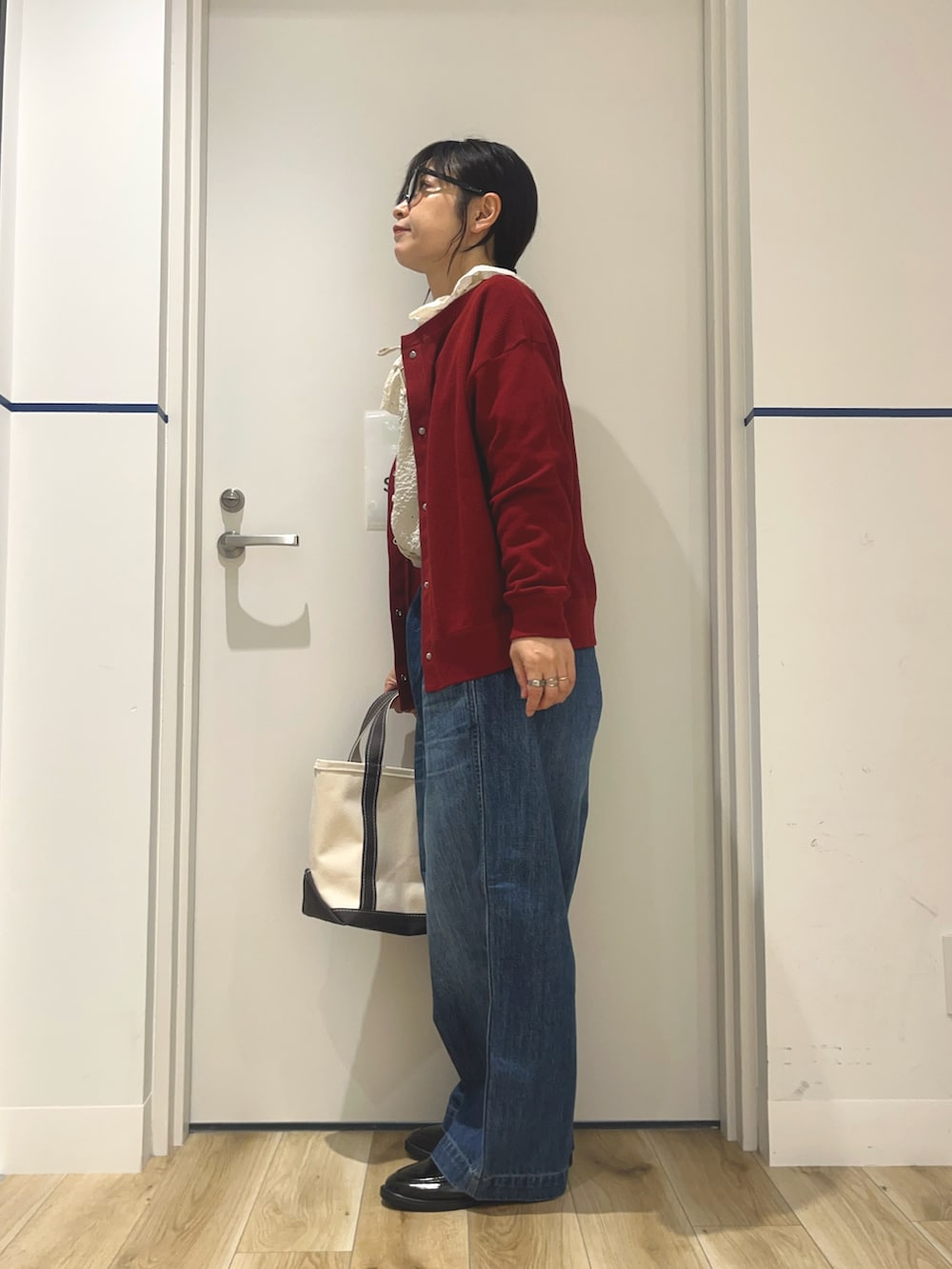 ブルー系のデニムパンツ、ブラック系のローファー、グレー系のトートバッグを着用したレディースの秋コーディネートの2枚目の写真