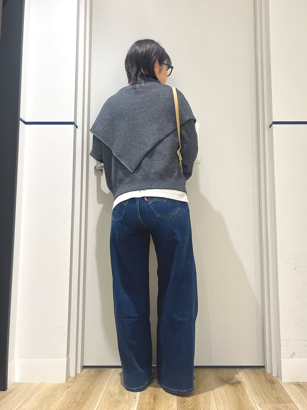 ブラック系のローファー、ブルー系のデニムパンツ、ブラック系のニット/セーターを着用したレディースの秋コーディネートの3枚目の写真