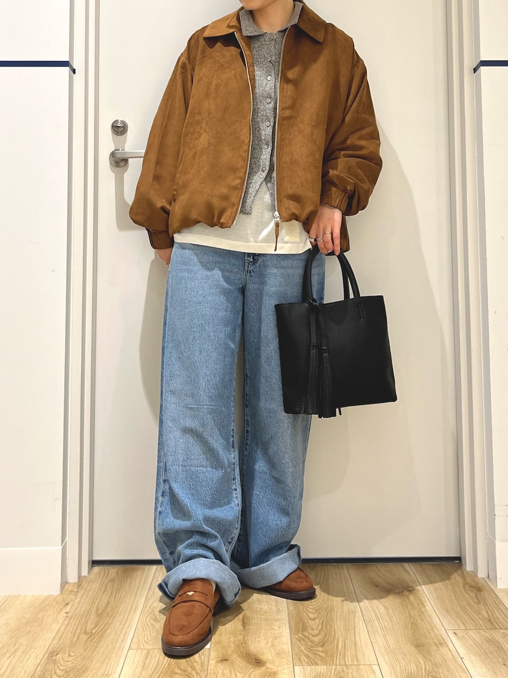 グレー系のニット/セーター、イエロー系のブルゾン、ブラック系のトートバッグを着用したレディースの秋コーディネートの4枚目の写真