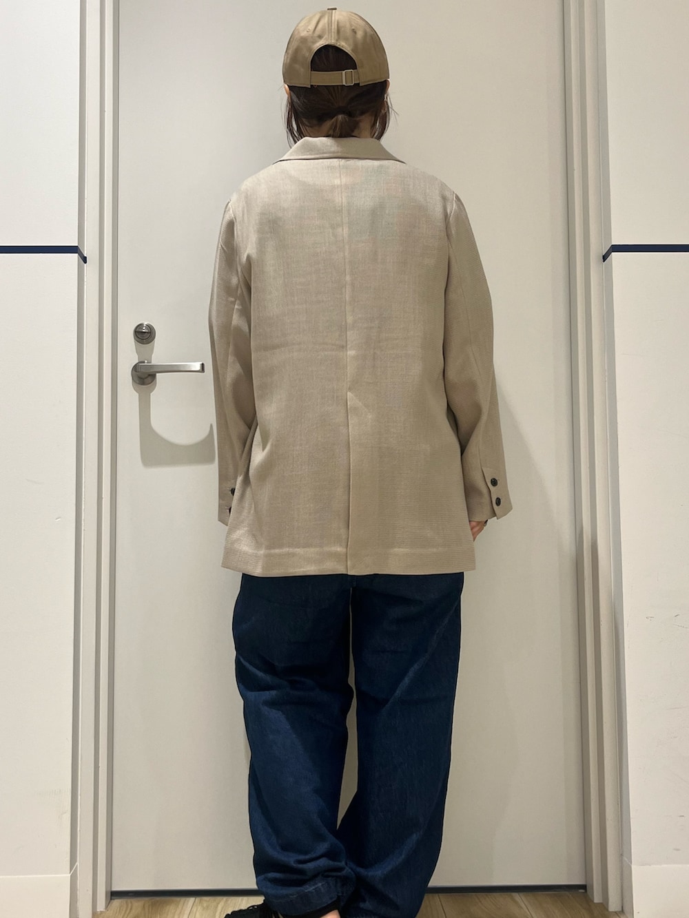 ブラック系のサンダル、ブルー系のデニムパンツ、レッド系のトートバッグを着用したレディースの春コーディネートの4枚目の写真