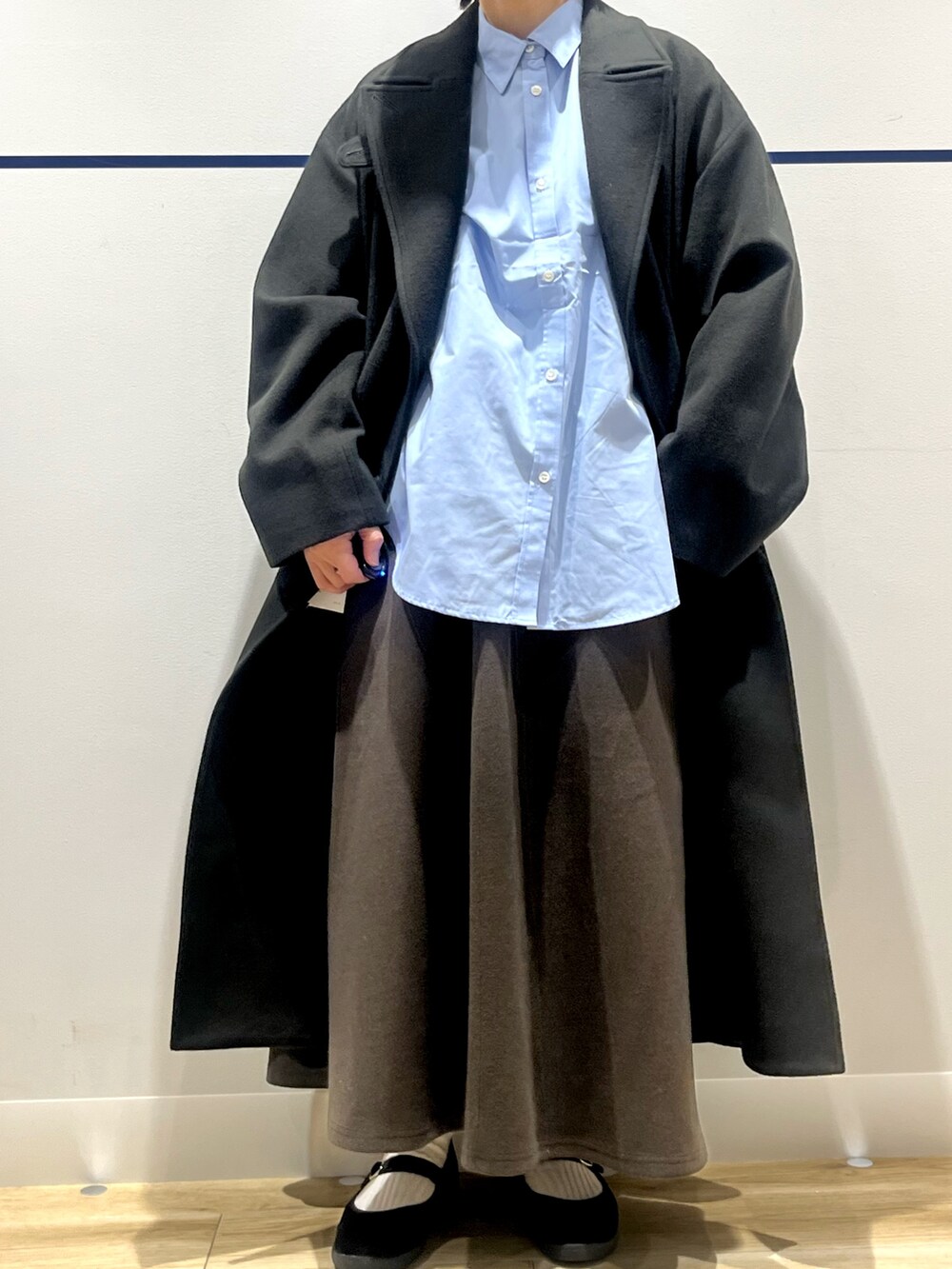 ブルー系のシャツ/ブラウス、グリーン系のチェスターコート、ブラウン系のスカートを着用したレディースの冬コーディネートの7枚目の写真