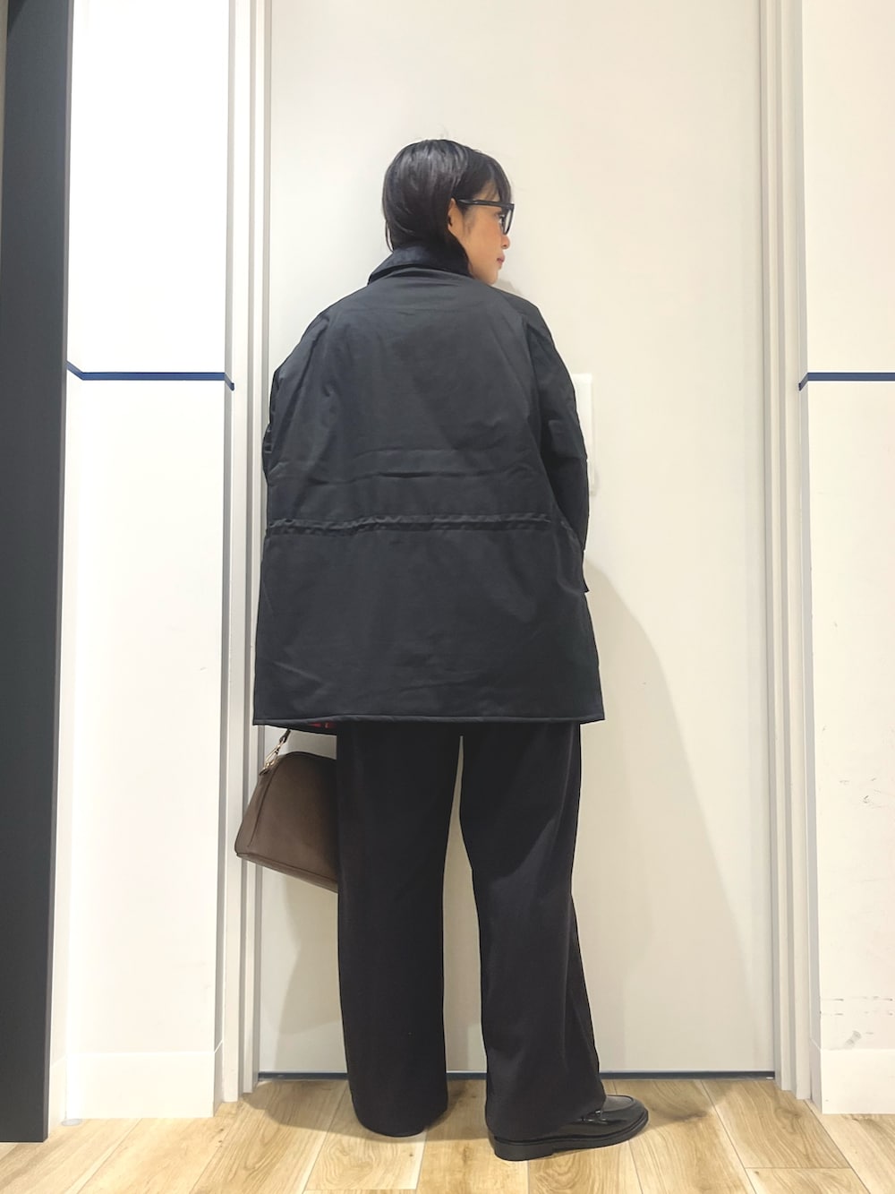 ブラック系のその他アウター、ホワイト系のカーディガン/ボレロ、ブラウン系のショルダーバッグを着用したレディースの秋コーディネートの3枚目の写真