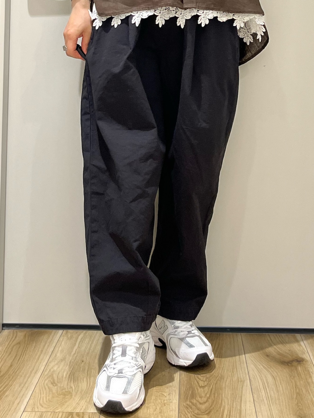 ブラック系のその他パンツ、シルバー系のスニーカー、ホワイト系のTシャツ/カットソーを着用したレディースの春コーディネートの5枚目の写真