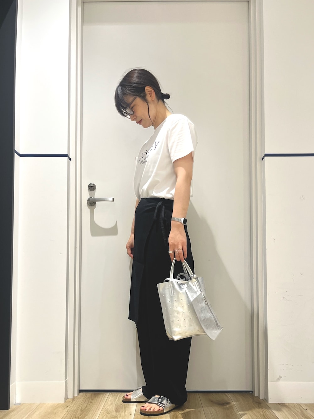 シルバー系のトートバッグ、ブラック系のその他パンツ、シルバー系のサンダルを着用したレディースの夏コーディネートの2枚目の写真