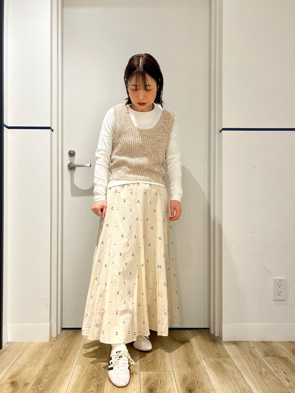 ブラック系のボストンバッグ、ホワイト系のスカート、ホワイト系のスニーカーを着用したレディースの春コーディネートの4枚目の写真