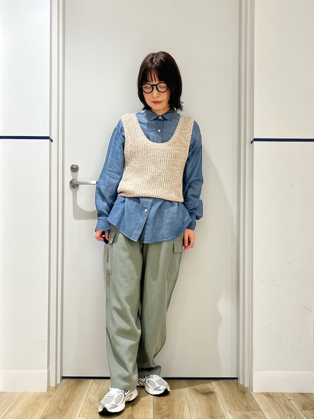 ベージュ系のベスト、ブルー系のシャツ/ブラウス、ブラウン系のトートバッグを着用したレディースの春コーディネートの3枚目の写真