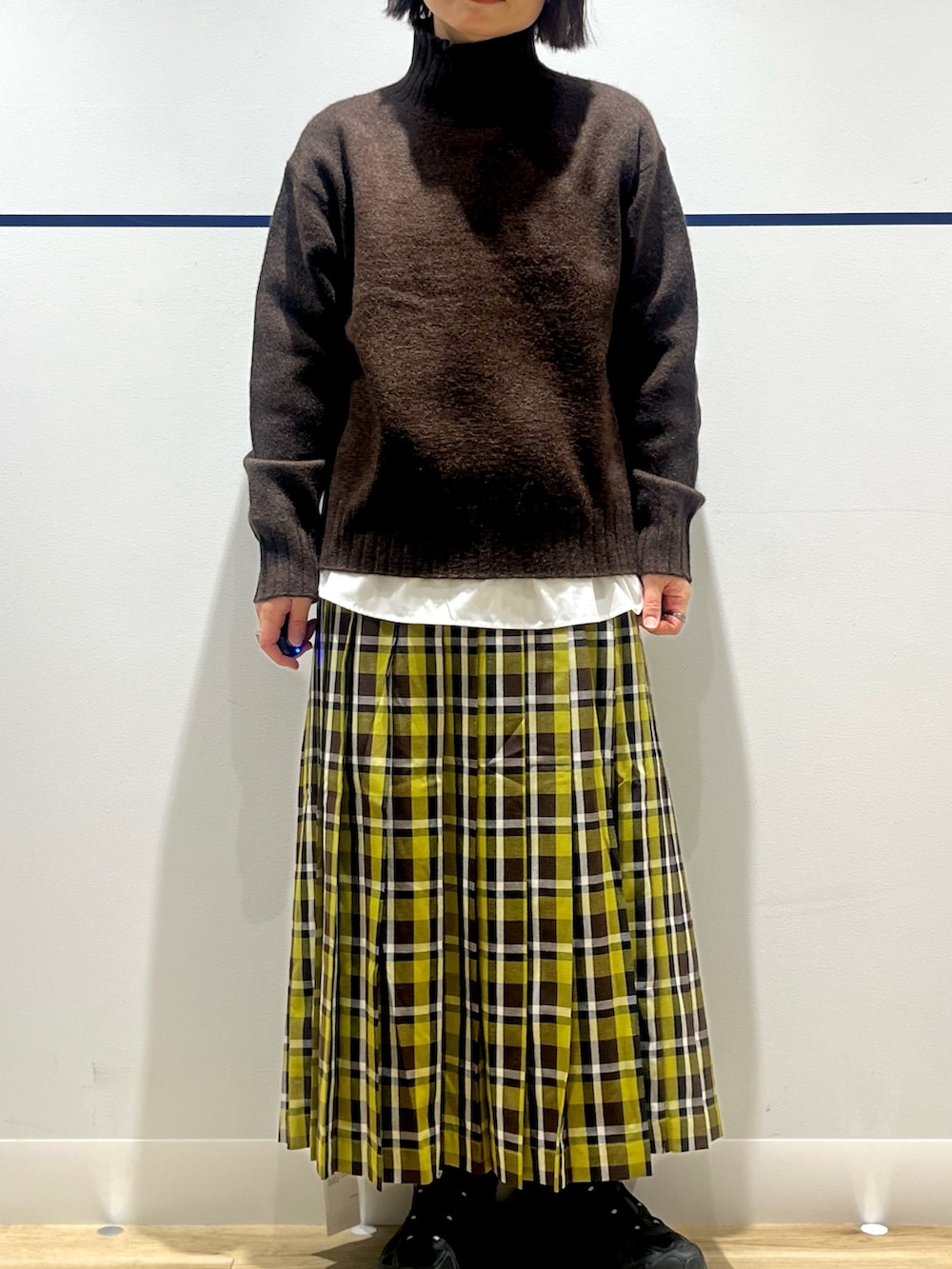 ブラック系のスニーカー、グリーン系のスカート、ホワイト系のシャツ/ブラウスを着用したレディースの冬コーディネートの3枚目の写真