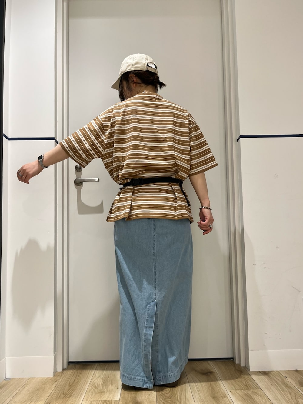ブラック系のボディバッグ/ウエストポーチ、ブラウン系のTシャツ/カットソー、ブルー系のスカートを着用したレディースの春コーディネートの2枚目の写真