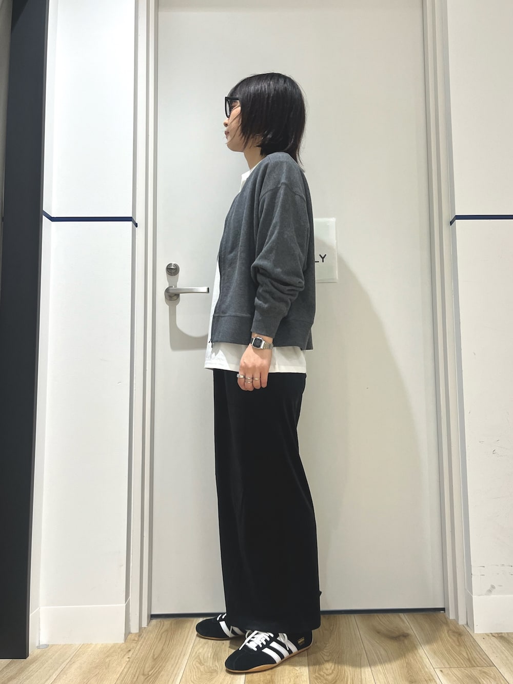 ブラック系のスニーカー、ブラック系のスカート、ホワイト系のTシャツ/カットソーを着用したレディースの秋コーディネートの2枚目の写真