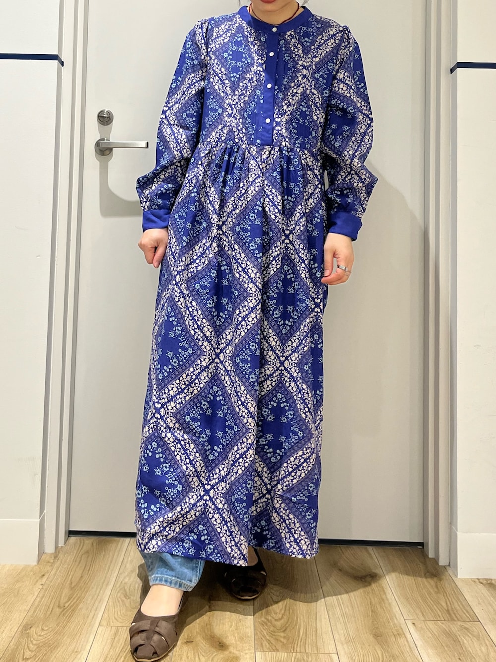 ブルー系のデニムパンツ、ブルー系のワンピース、ブラウン系のパンプスを着用したレディースの春コーディネートの7枚目の写真