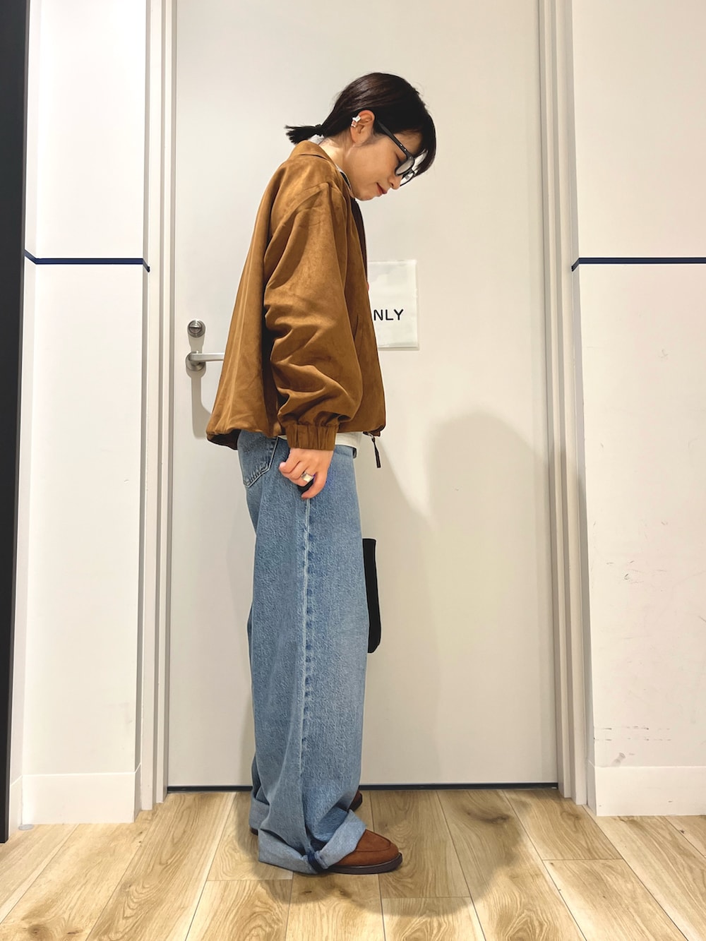 グレー系のニット/セーター、イエロー系のブルゾン、ブラック系のトートバッグを着用したレディースの秋コーディネートの2枚目の写真