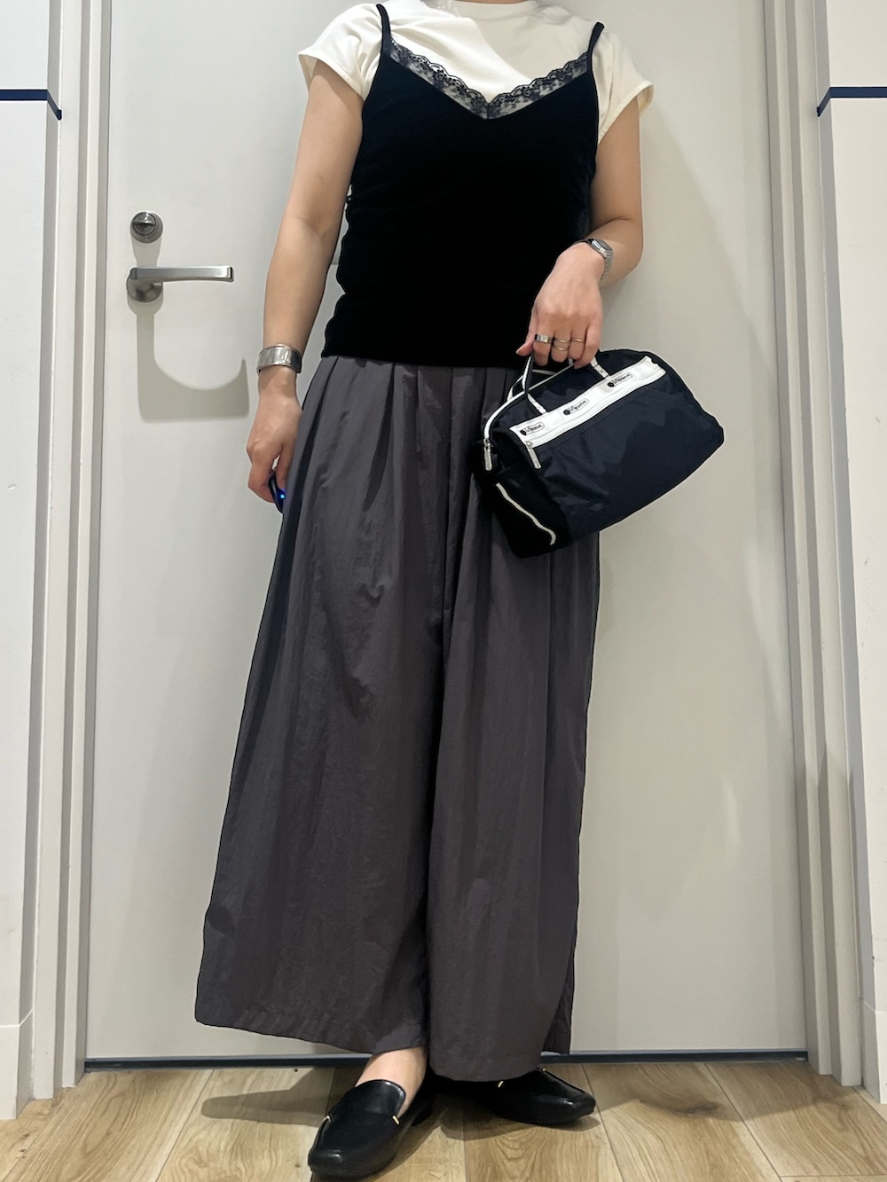 ブラック系のショルダーバッグ、グレー系のその他パンツ、ホワイト系のTシャツ/カットソーを着用したレディースの夏コーディネートの3枚目の写真