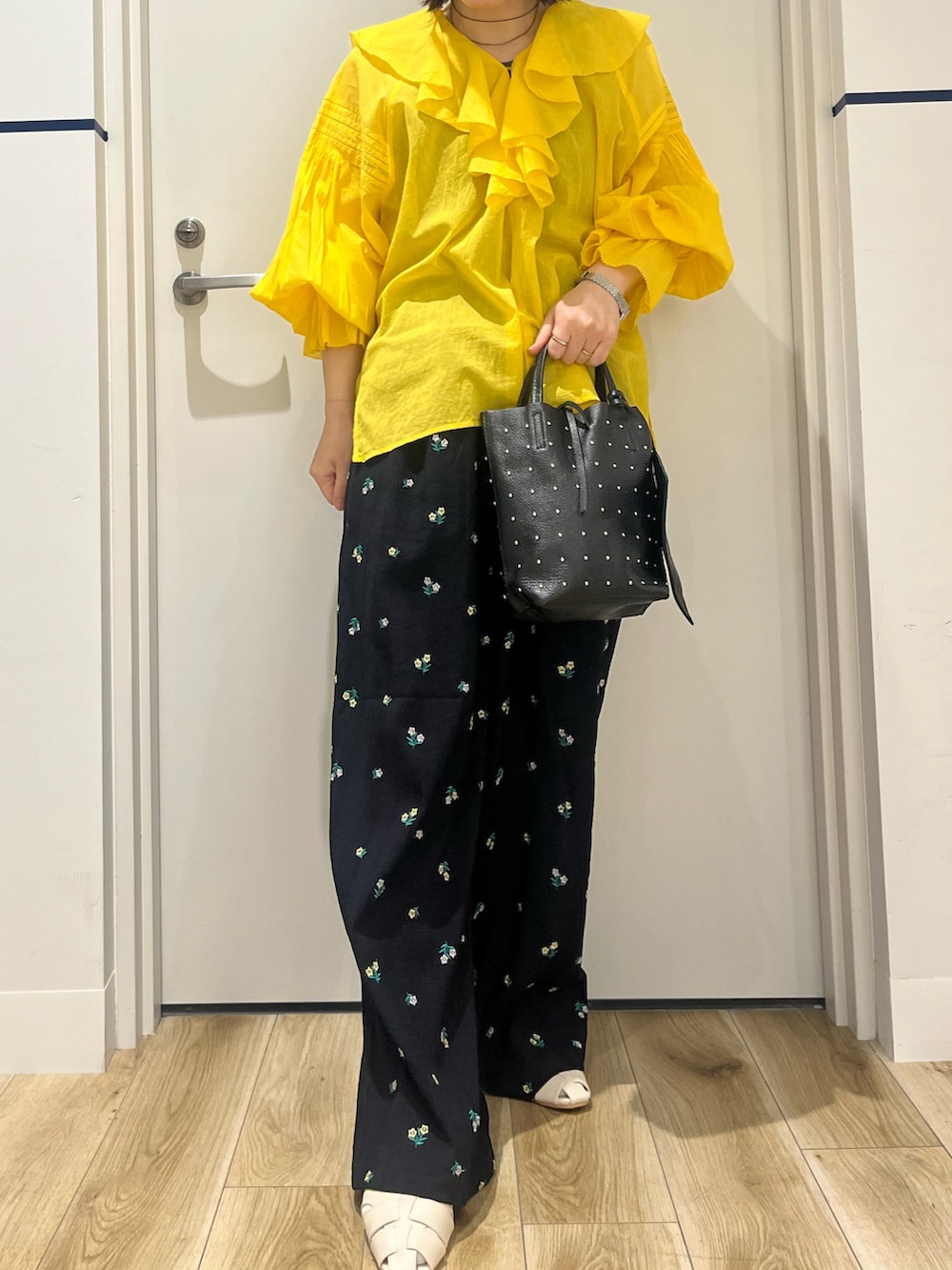 ブラック系のトートバッグ、ブルー系のその他パンツ、ホワイト系のパンプスを着用したレディースの春コーディネートの4枚目の写真