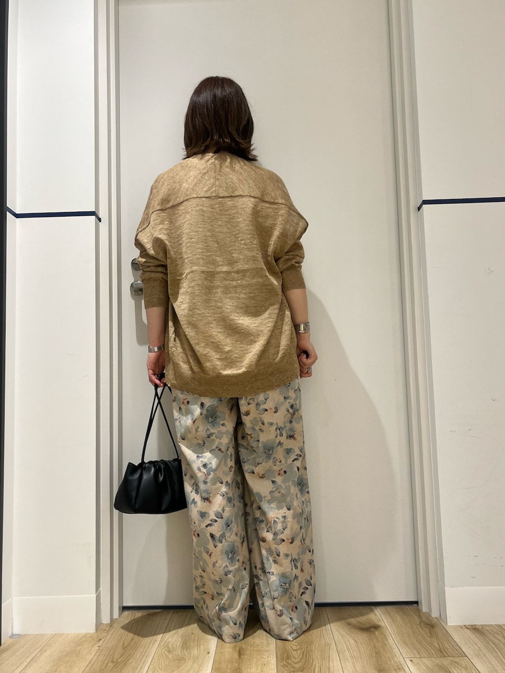 ベージュ系のカーディガン/ボレロ、ホワイト系のシャツ/ブラウス、ブラック系のショルダーバッグを着用したレディースの春コーディネートの3枚目の写真