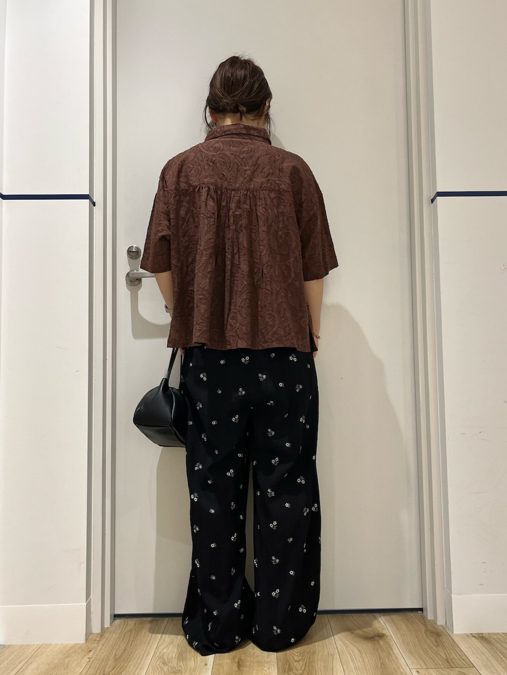 ブラウン系のシャツ/ブラウス、ブラック系のショルダーバッグ、ブルー系のその他パンツを着用したレディースの春コーディネートの3枚目の写真