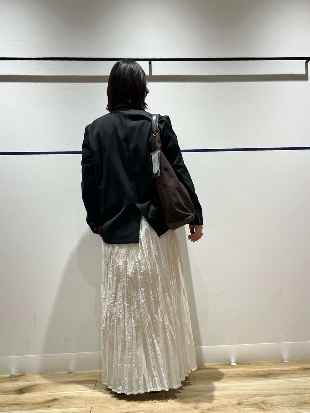 ブラウン系のトートバッグ、グリーン系のニット/セーター、ブラック系のその他アウターを着用したレディースの冬コーディネートの3枚目の写真