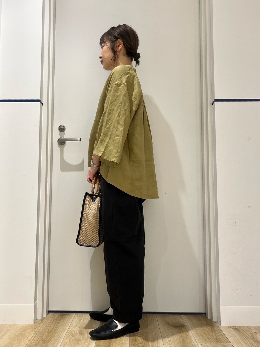 ブラック系のローファー、ブラック系のその他パンツ、ベージュ系のショルダーバッグを着用したレディースの春コーディネートの2枚目の写真