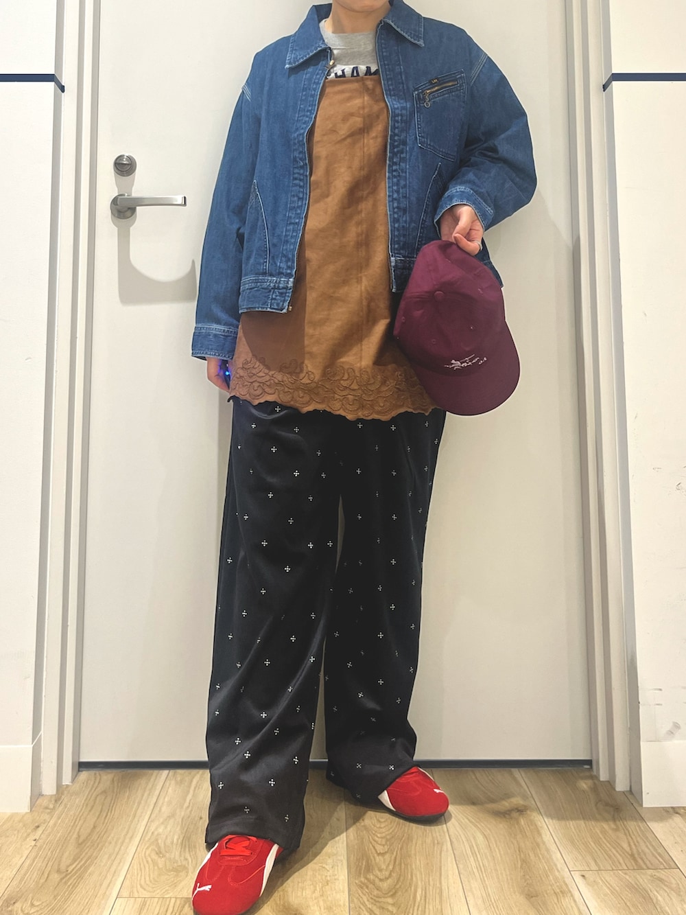 ブラック系のその他パンツ、レッド系のスニーカー、ブルー系のデニムジャケットを着用したレディースの秋コーディネートの4枚目の写真
