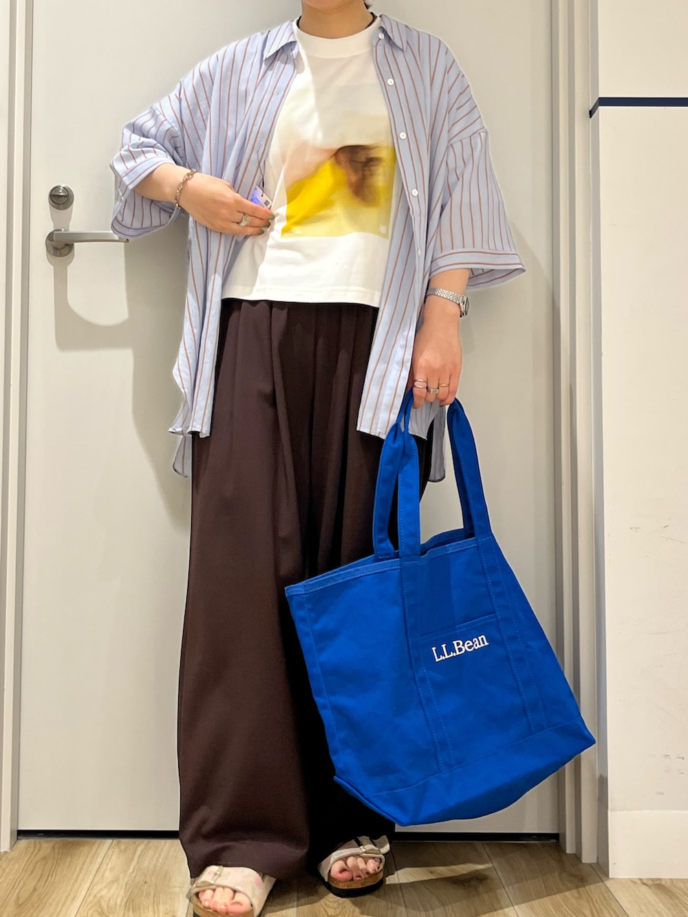 ブラウン系のその他パンツ、ベージュ系のサンダル、ブルー系のトートバッグを着用したレディースの夏コーディネートの4枚目の写真