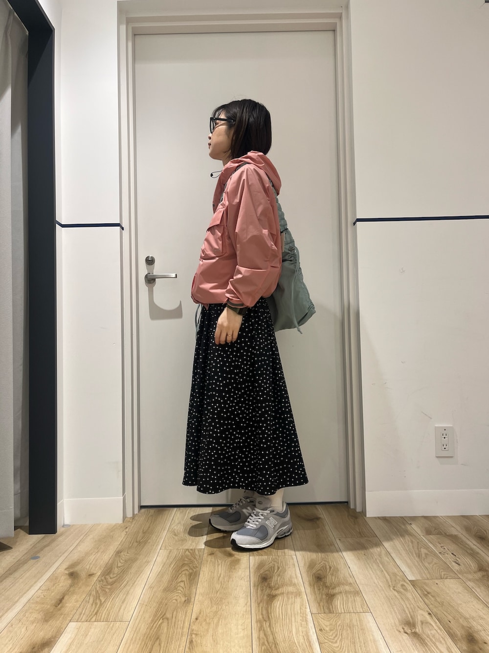 ベージュ系のスニーカー、ブラック系のワンピース、ピンク系のナイロンジャケットを着用したレディースの冬コーディネートの4枚目の写真