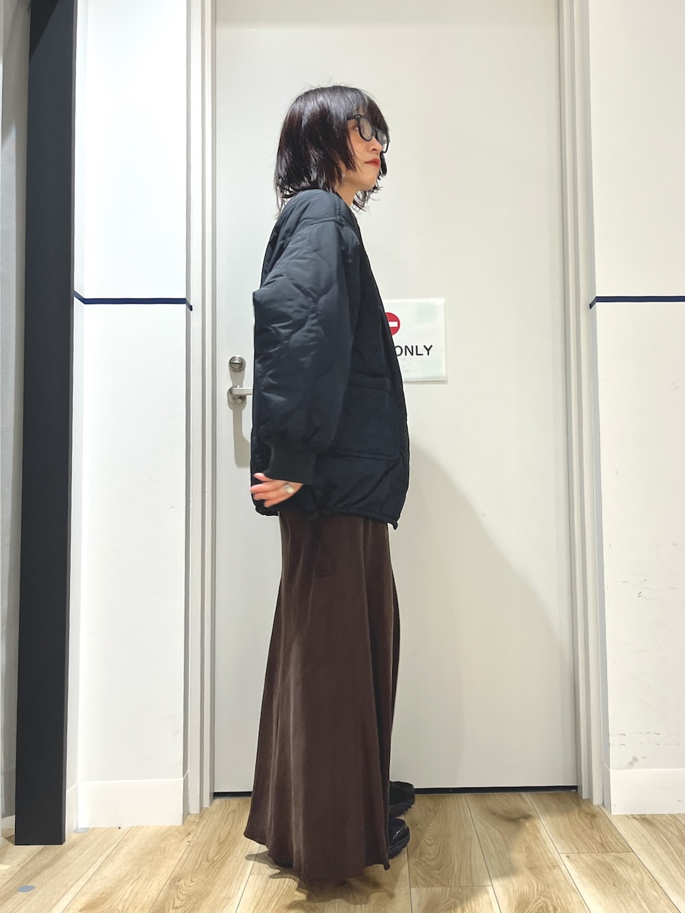 ホワイト系のTシャツ/カットソー、グレー系のニット/セーター、ブラック系のブルゾンを着用したレディースの秋コーディネートの2枚目の写真