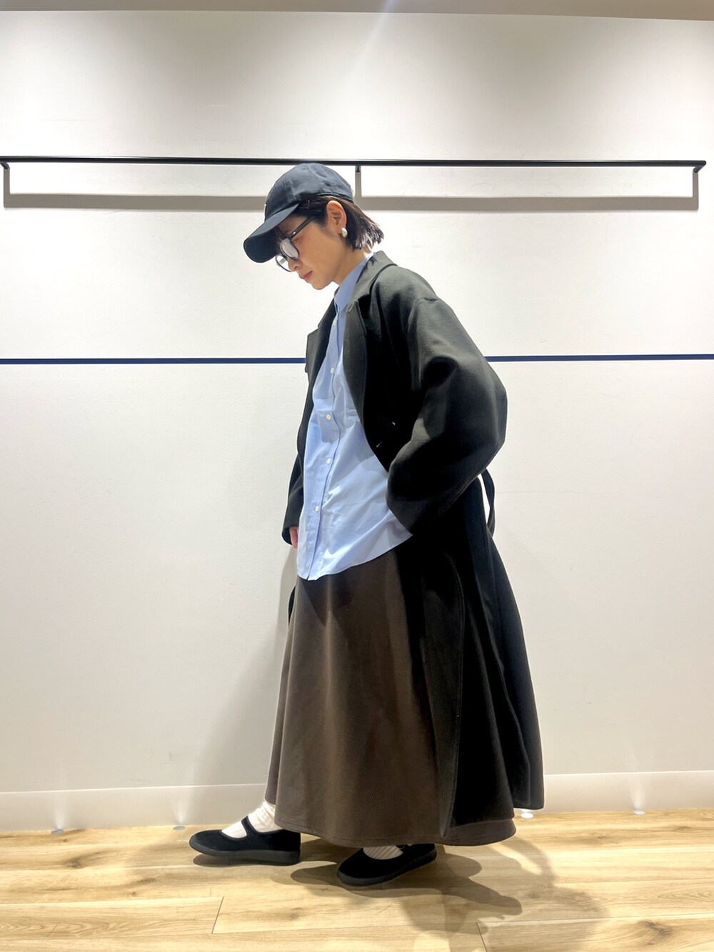 ブルー系のシャツ/ブラウス、グリーン系のチェスターコート、ブラウン系のスカートを着用したレディースの冬コーディネートの3枚目の写真