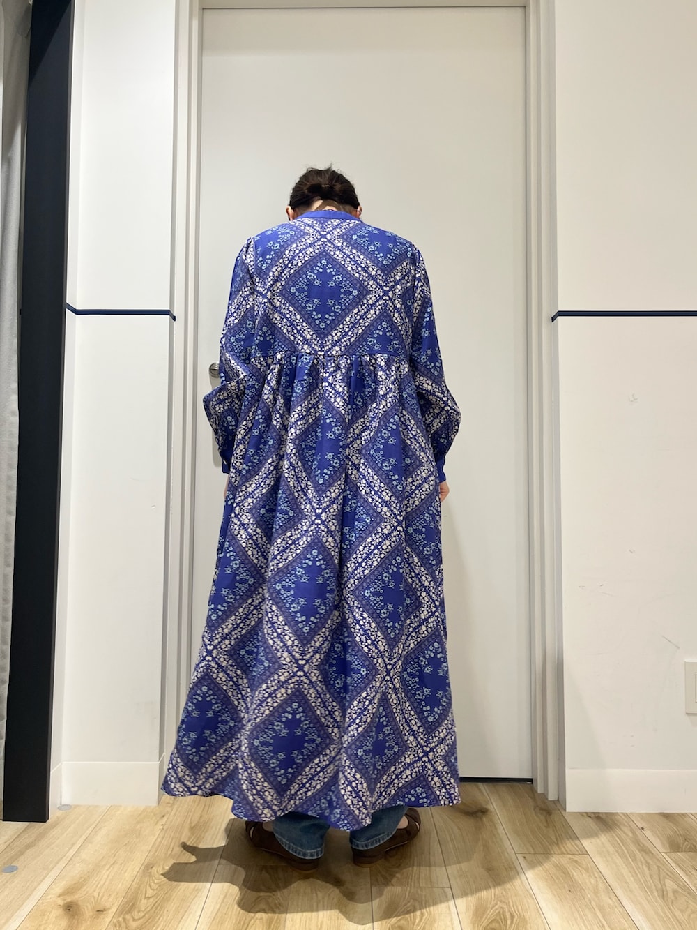 ブルー系のデニムパンツ、ブルー系のワンピース、ブラウン系のパンプスを着用したレディースの春コーディネートの6枚目の写真