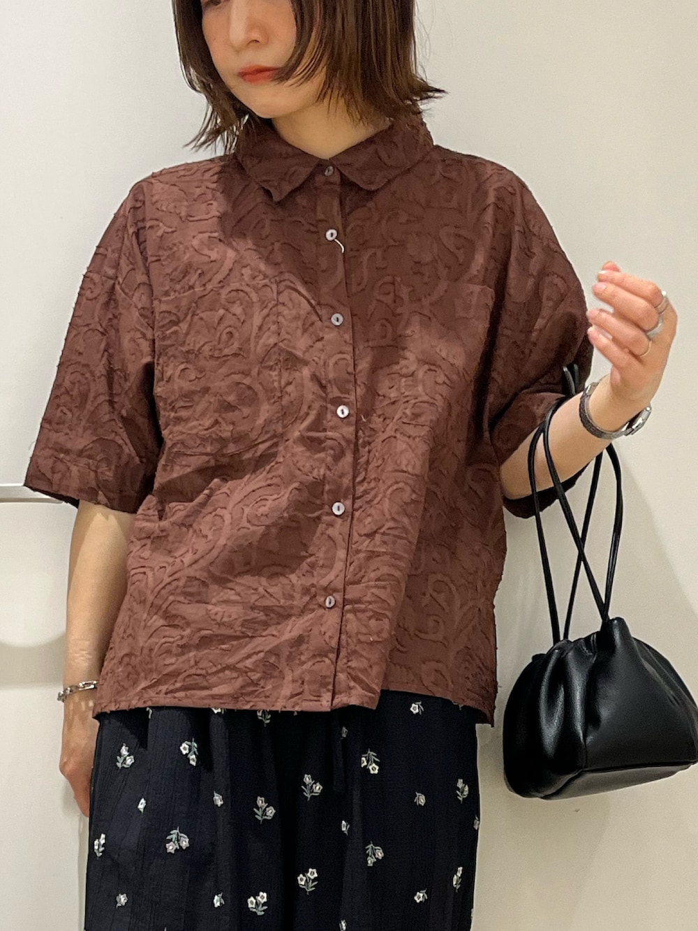 ブラウン系のシャツ/ブラウス、ブラック系のショルダーバッグ、ブルー系のその他パンツを着用したレディースの春コーディネートの4枚目の写真