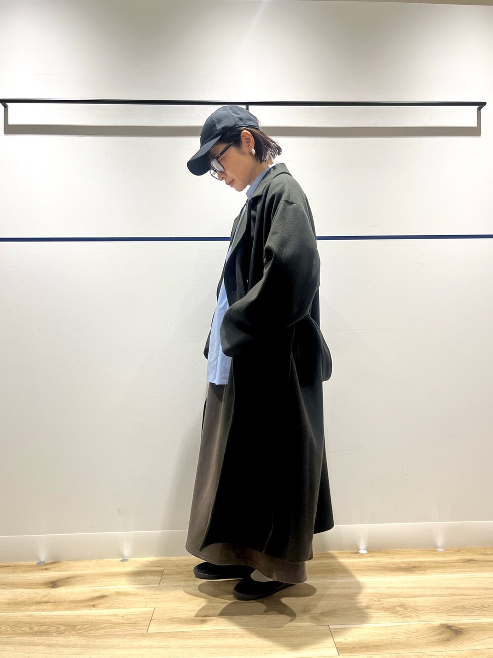 ブルー系のシャツ/ブラウス、グリーン系のチェスターコート、ブラウン系のスカートを着用したレディースの冬コーディネートの4枚目の写真