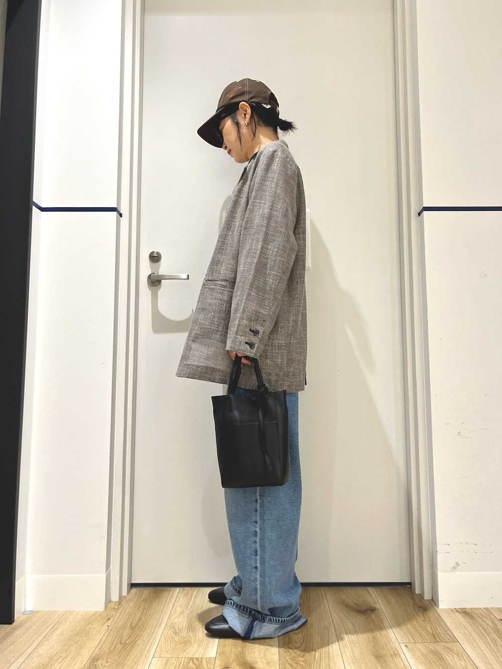 グレー系のその他アウター、ブルー系のデニムパンツ、ブラック系のトートバッグを着用したレディースの秋コーディネートの2枚目の写真