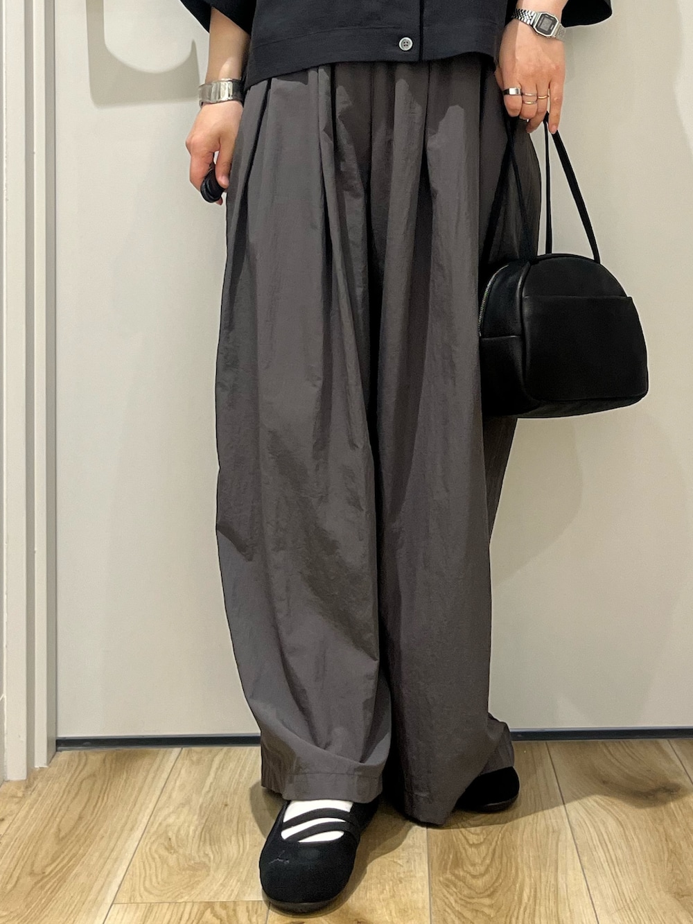 ブラック系のボストンバッグ、ブラック系のシャツ/ブラウス、グレー系のその他パンツを着用したレディースの春コーディネートの5枚目の写真