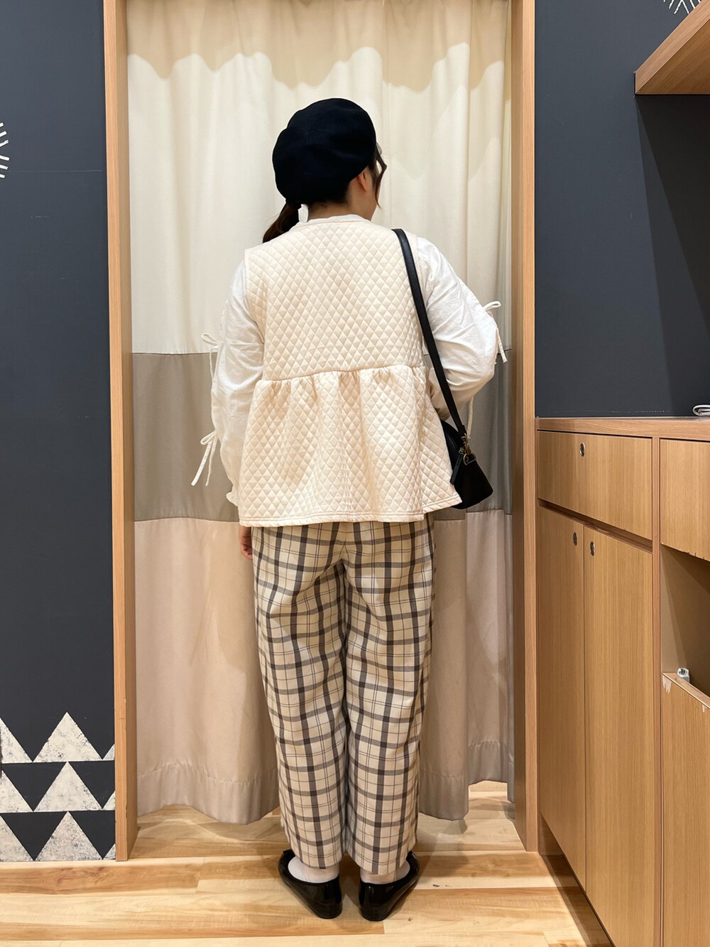 ホワイト系のベスト、ブラック系のハンドバッグ、ホワイト系のシャツ/ブラウスを着用したレディースの春コーディネートの2枚目の写真