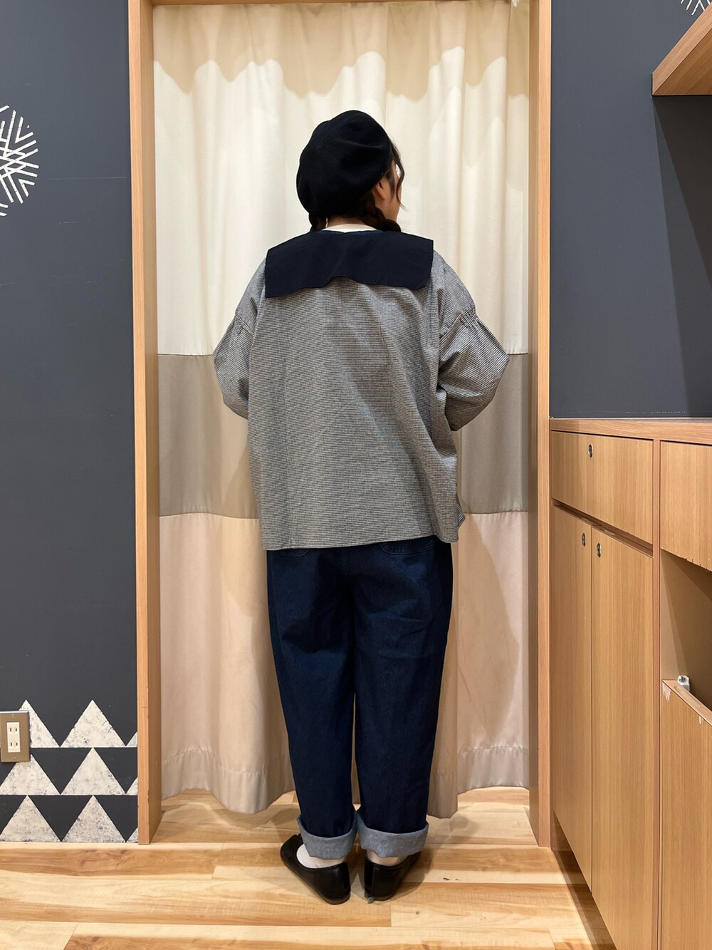 グレー系のシャツ/ブラウス、ホワイト系のニット/セーター、ブラック系のハットを着用したレディースの冬コーディネートの2枚目の写真