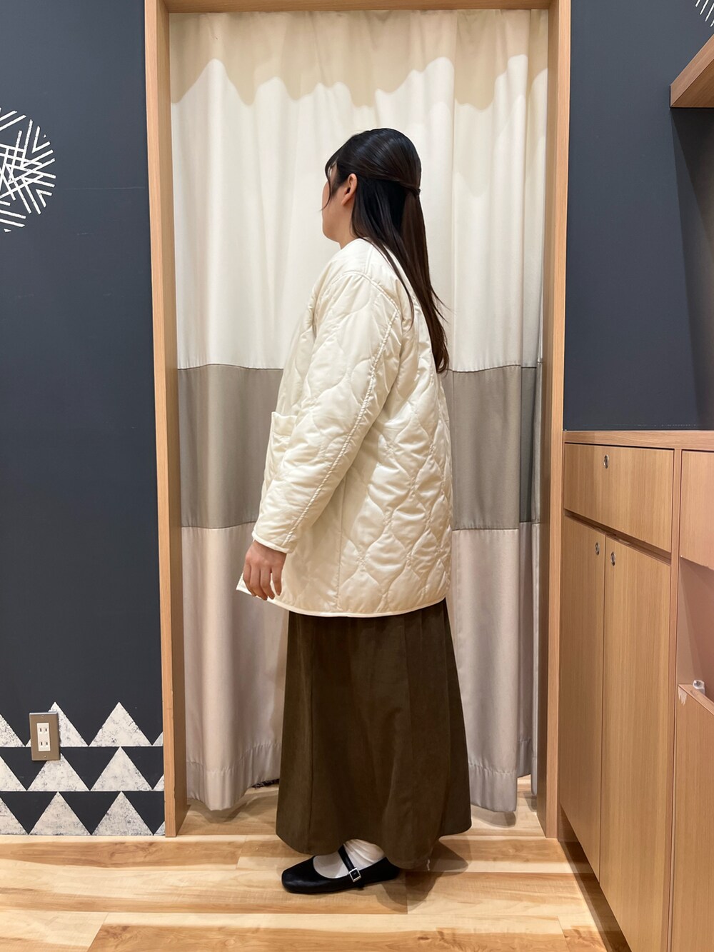 ブラウン系のワンピース、ホワイト系のその他アウター、ホワイト系のTシャツ/カットソーを着用したレディースの冬コーディネートの3枚目の写真