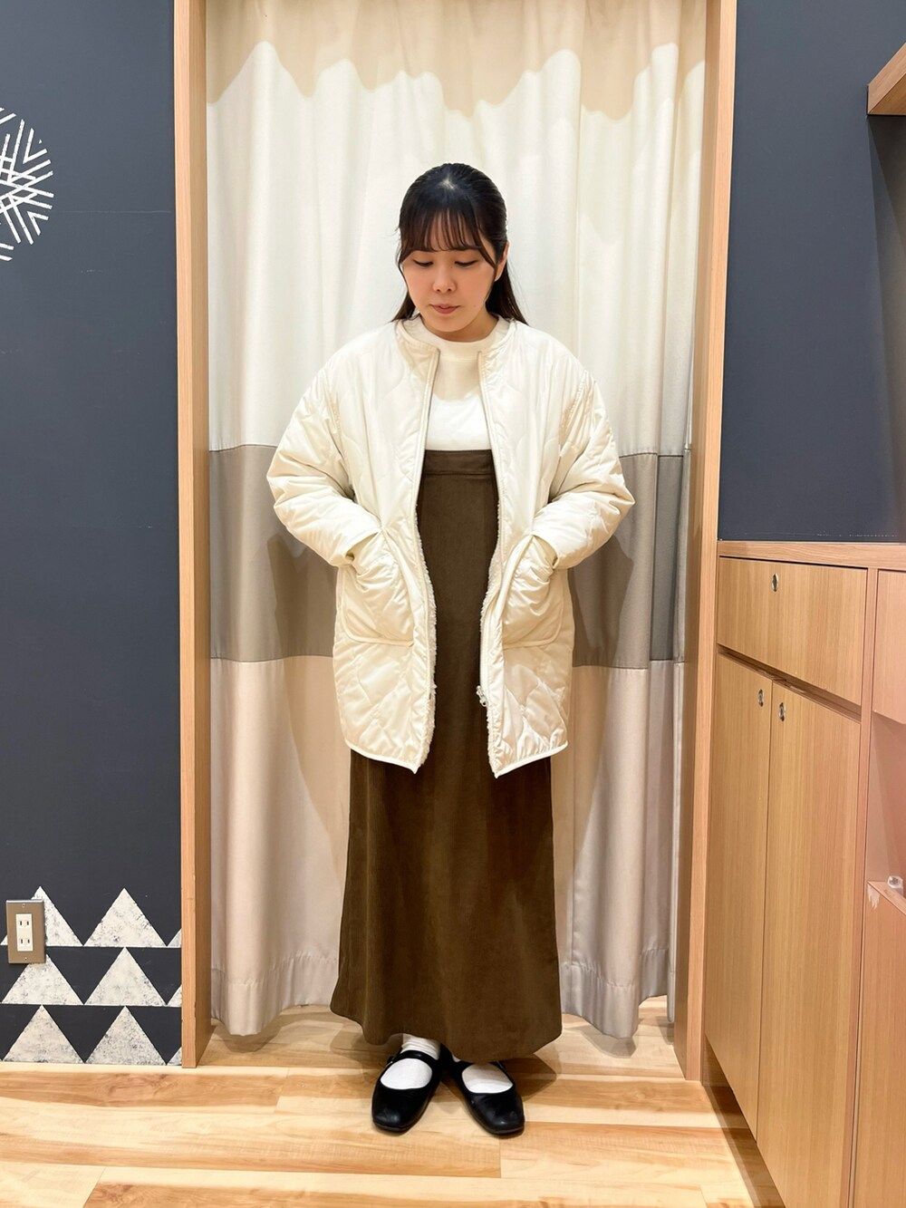 ブラウン系のワンピース、ホワイト系のその他アウター、ホワイト系のTシャツ/カットソーを着用したレディースの冬コーディネートの2枚目の写真