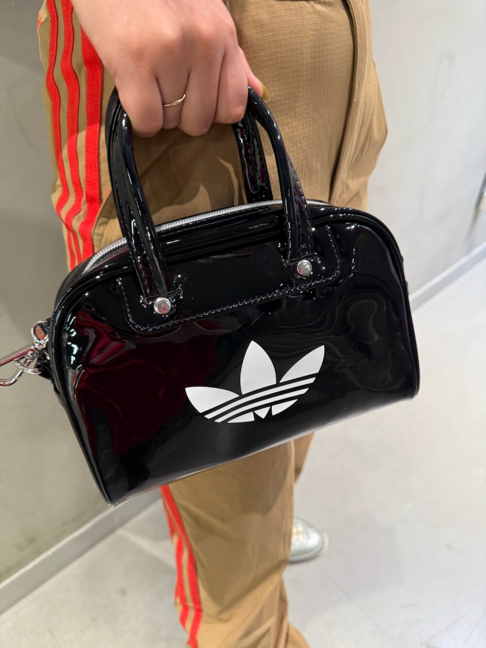 ブラウン系のその他パンツ、グレー系のスニーカー、ブラック系のショルダーバッグを着用したレディースの夏コーディネートの3枚目の写真