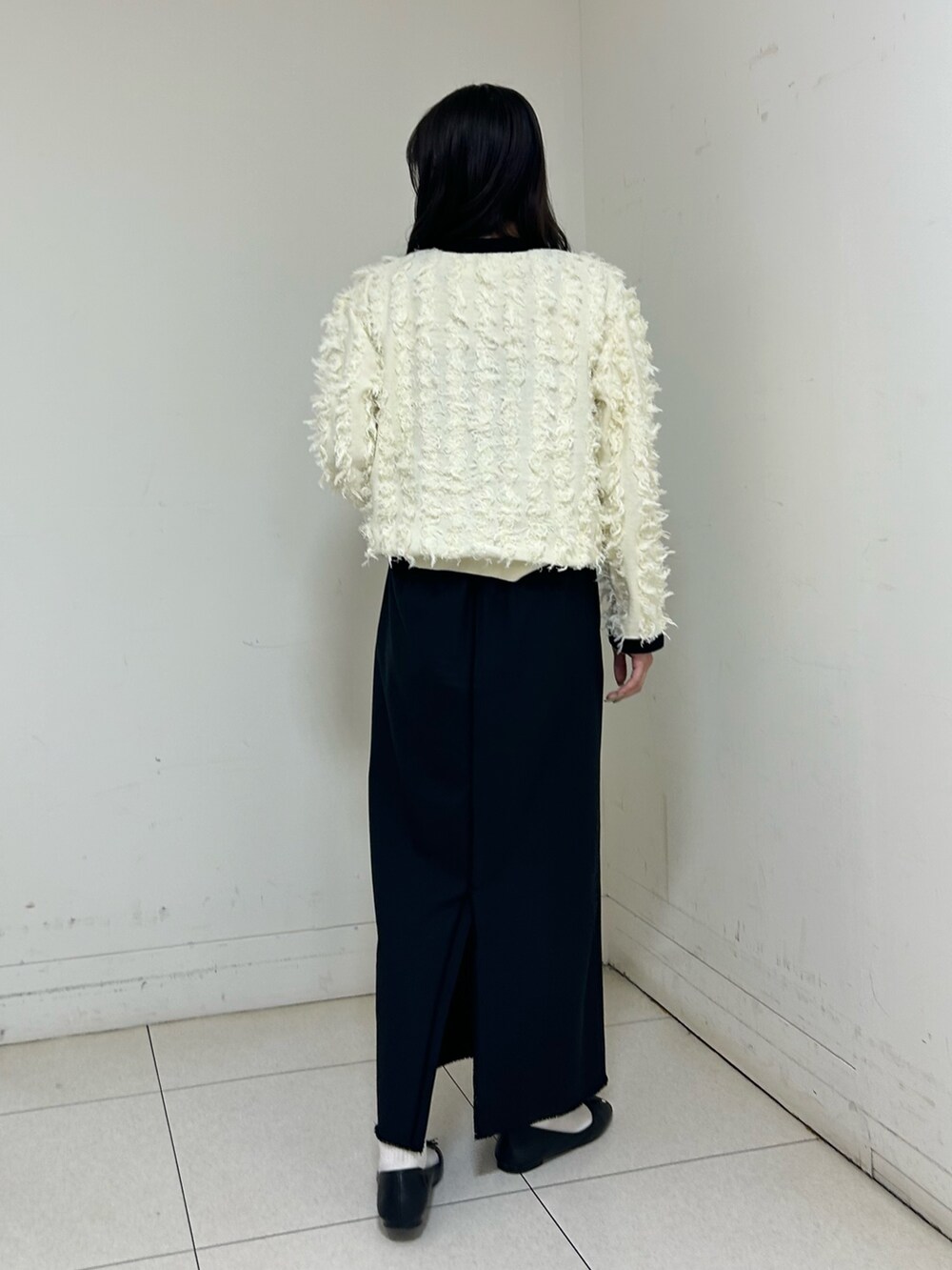 ホワイト系のカーディガン/ボレロ、ブラック系のスカートを着用したレディースの春コーディネートの4枚目の写真