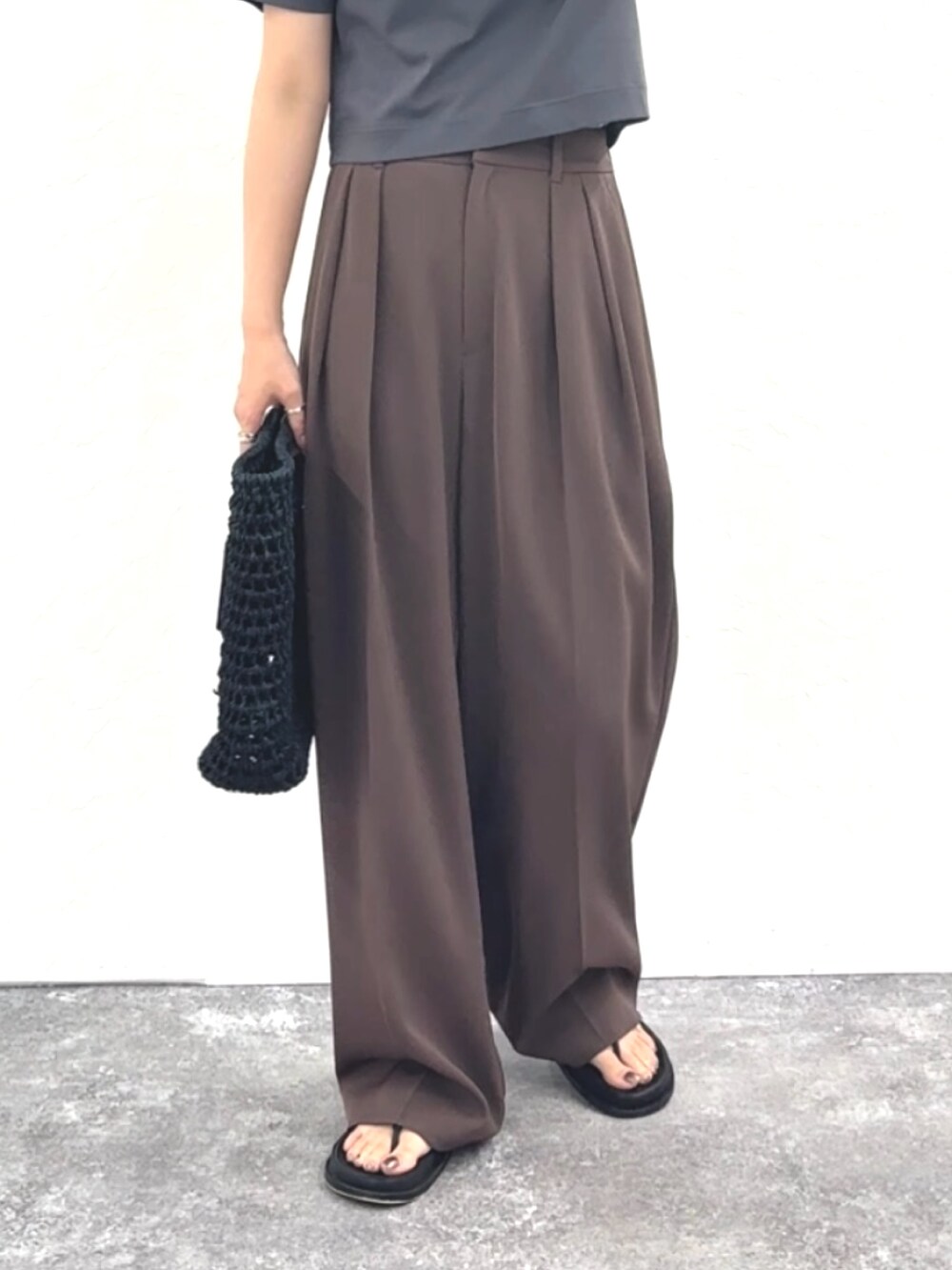 グレー系のTシャツ/カットソー、ブラウン系のその他パンツ、ブラック系のかごバッグを着用したレディースの春コーディネートの6枚目の写真