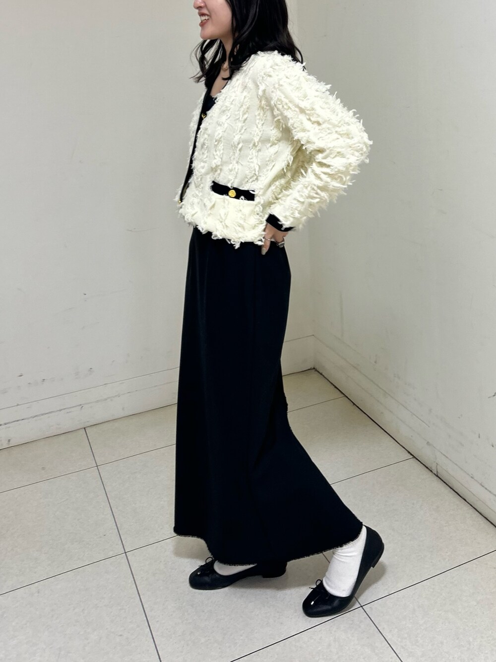 ホワイト系のカーディガン/ボレロ、ブラック系のスカートを着用したレディースの春コーディネートの6枚目の写真