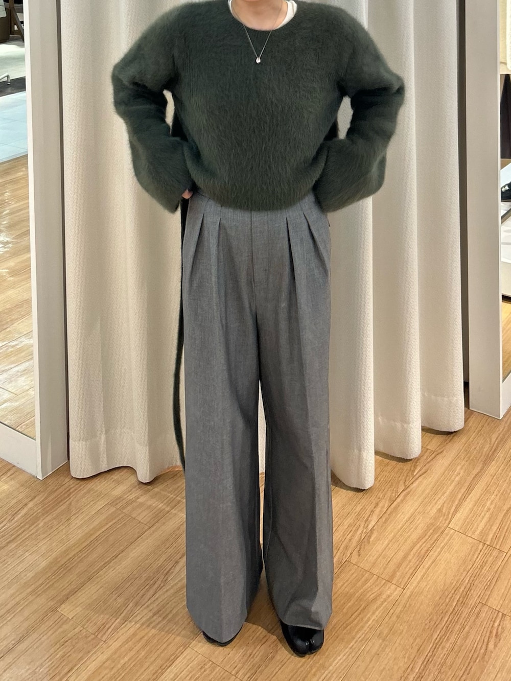 グリーン系のニット/セーターを着用したレディースの冬コーディネートの3枚目の写真