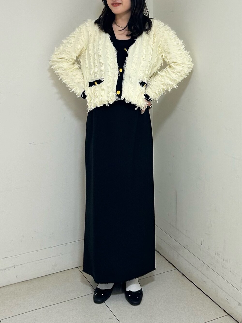 ホワイト系のカーディガン/ボレロ、ブラック系のスカートを着用したレディースの春コーディネートの2枚目の写真