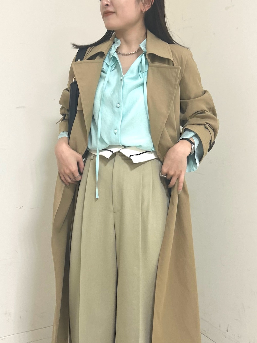ブラック系のショルダーバッグ、グリーン系のシャツ/ブラウス、ベージュ系のその他パンツを着用したレディースの春コーディネートの2枚目の写真