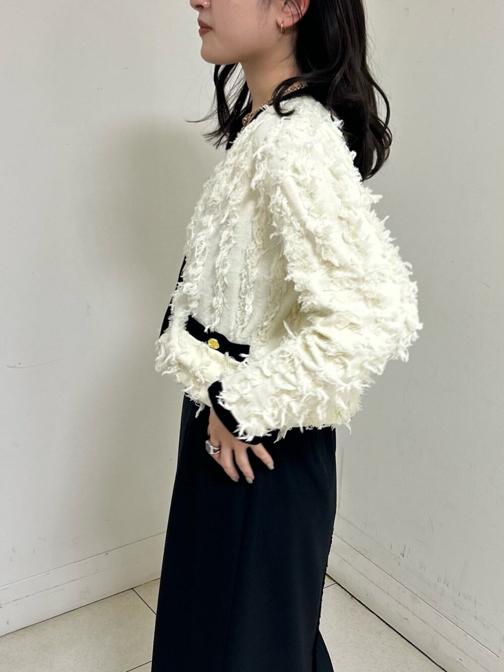 ホワイト系のカーディガン/ボレロ、ブラック系のスカートを着用したレディースの春コーディネートの5枚目の写真