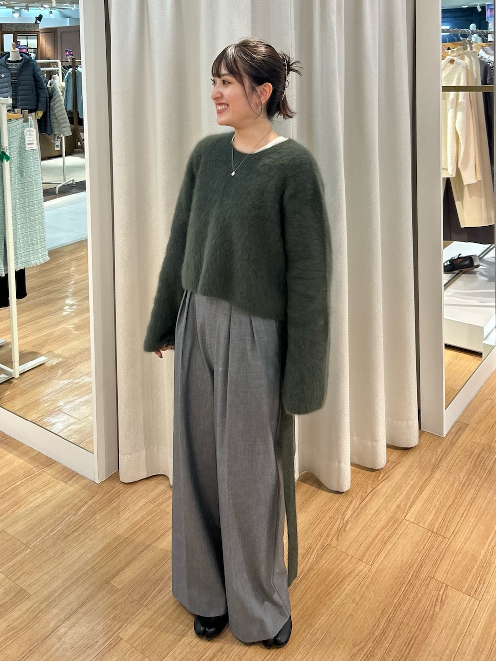 グリーン系のニット/セーターを着用したレディースの冬コーディネートの2枚目の写真