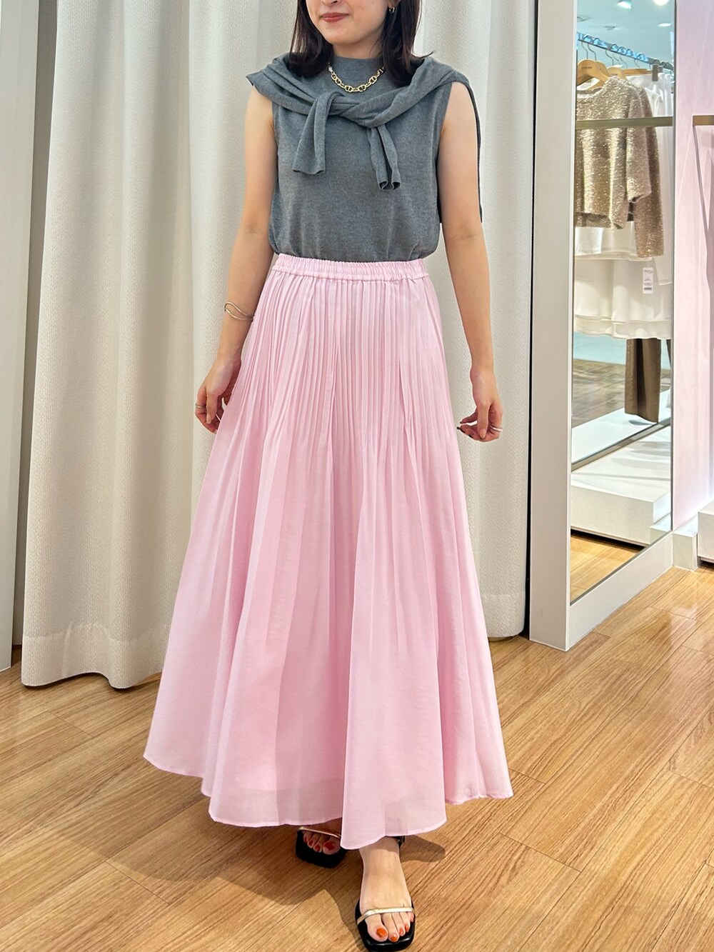 ピンク系のスカート、グレー系のカーディガン/ボレロ、グレー系のニット/セーターを着用したレディースの夏コーディネートの5枚目の写真